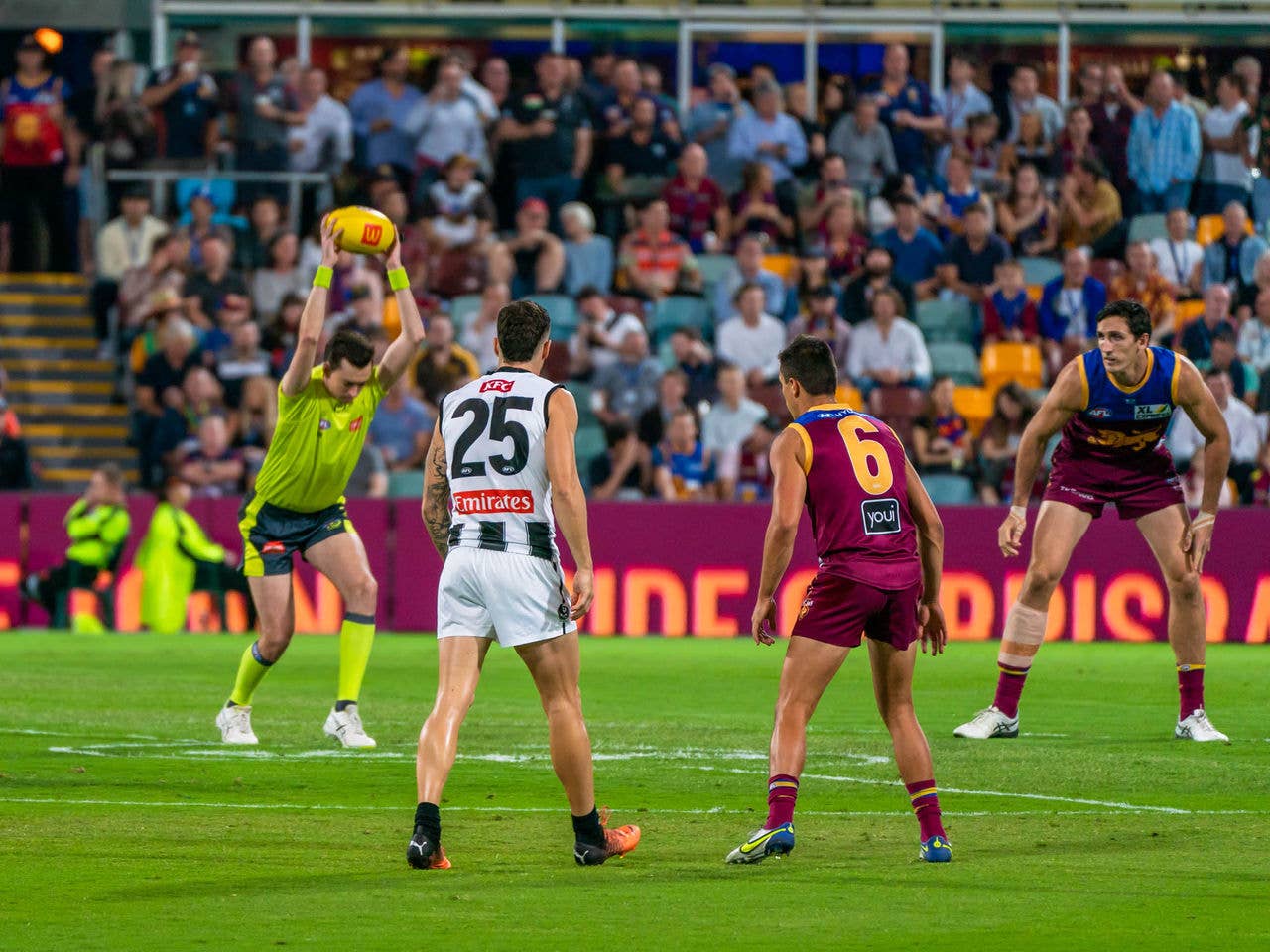 An AFL ball bounce as two players prepare to jump for the ball