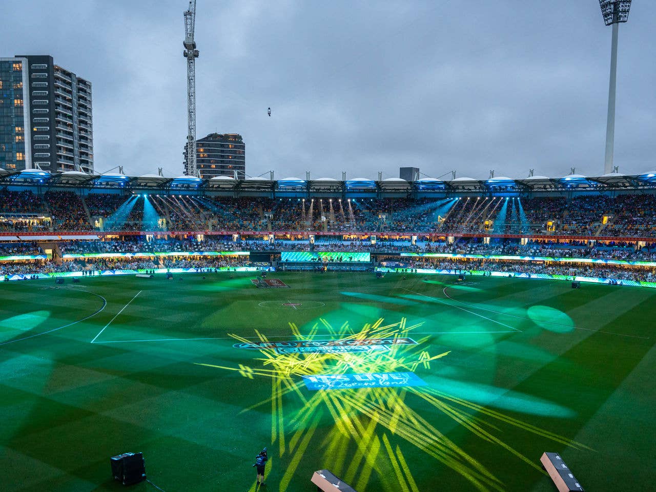 Inside the gabba stadium is lit up with green, yellow and blue lights