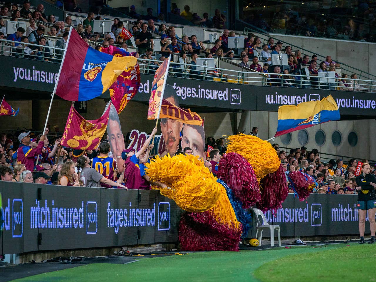 View from field into crowd. Brisbane Lions fans waving flags and pom poms